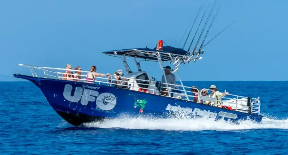 blue fishing boat UFO with tourists cruising on the ocean under clear sky