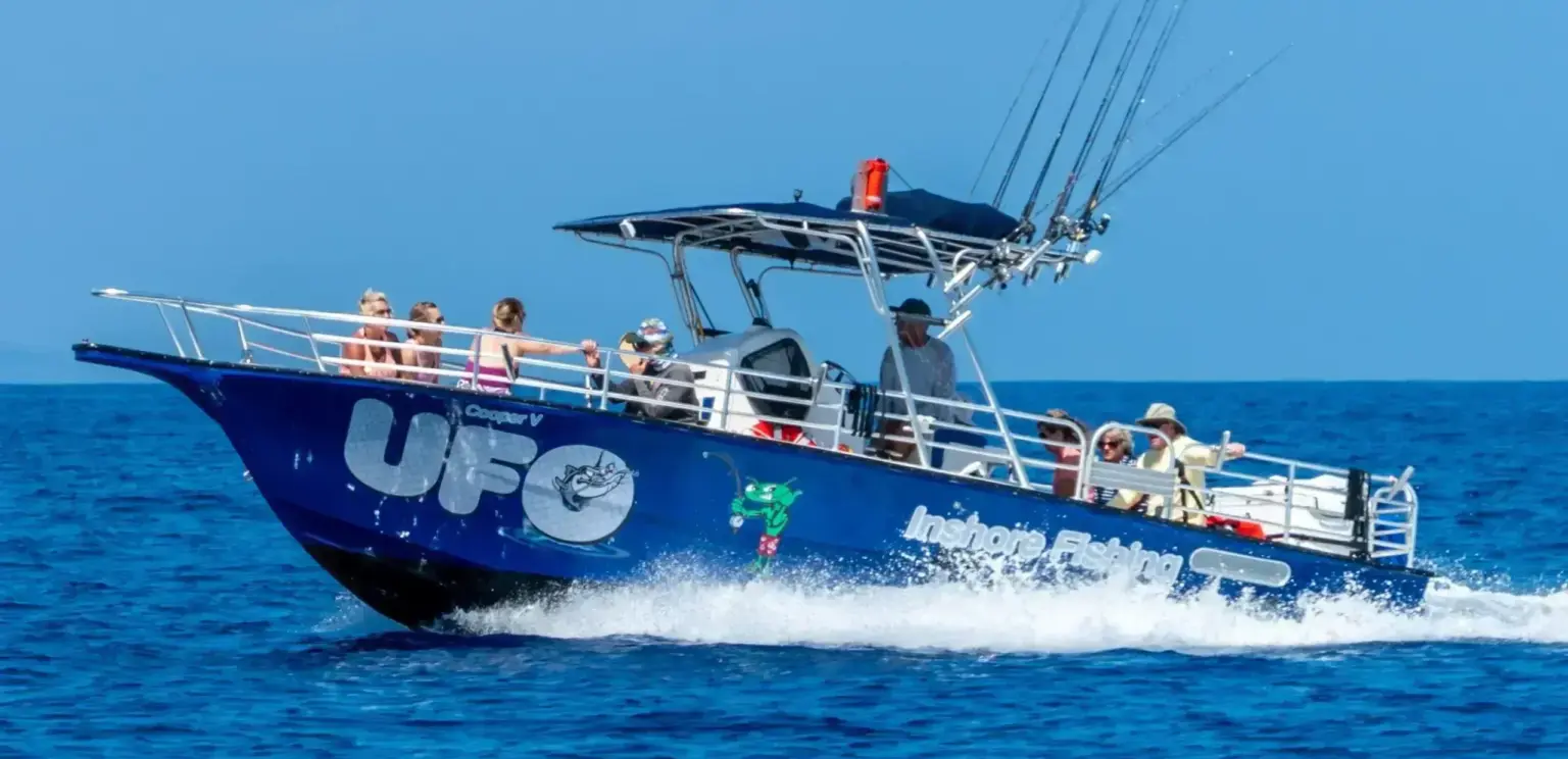 blue fishing boat UFO with tourists cruising on the ocean under clear sky