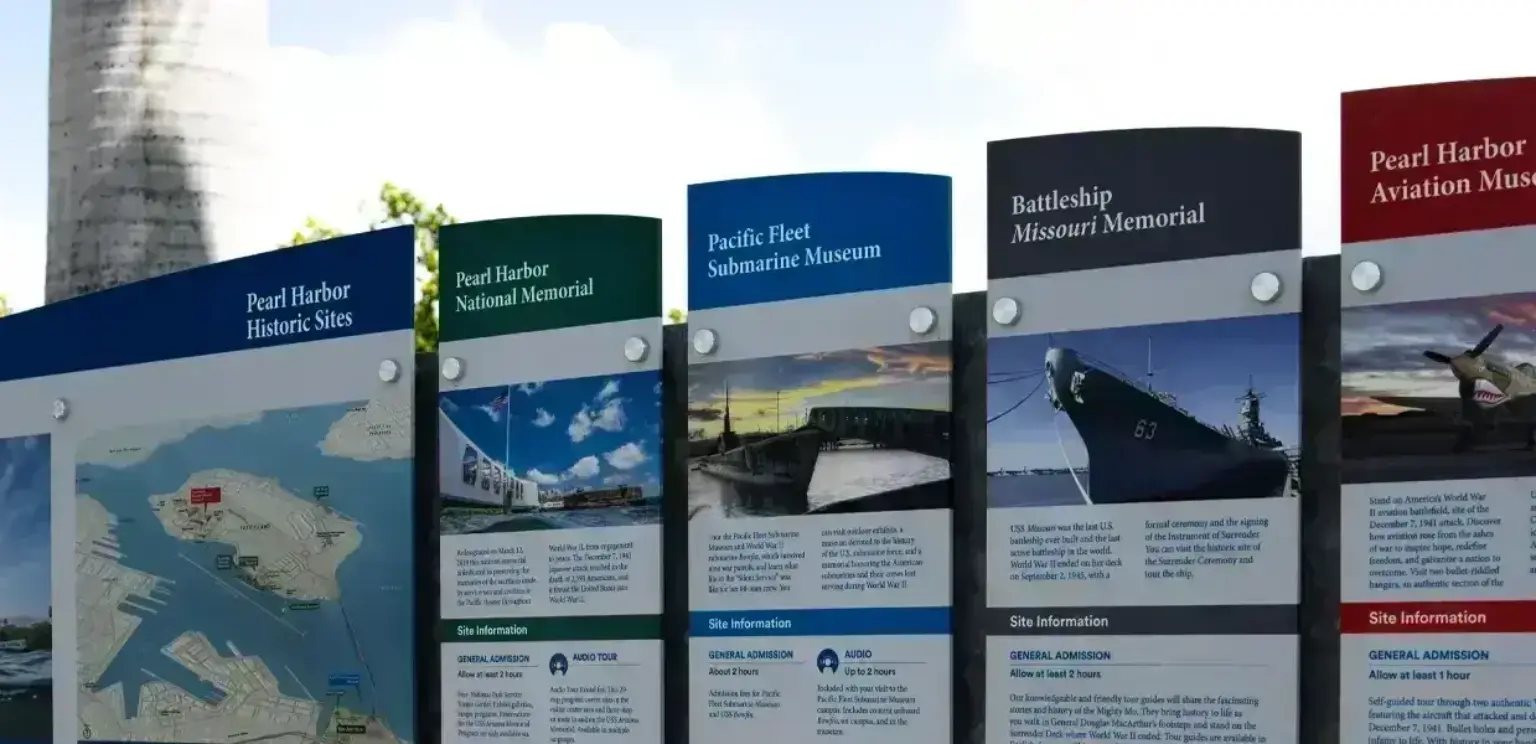 Informational signs at Pearl Harbor historic sites listing museum details and site information