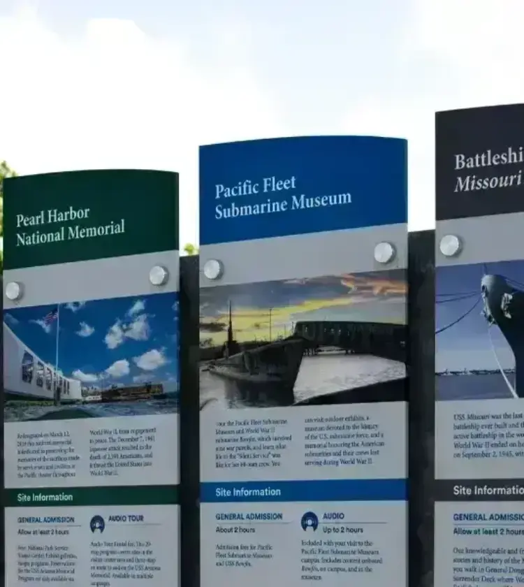 Informational signs at Pearl Harbor historic sites listing museum details and site information