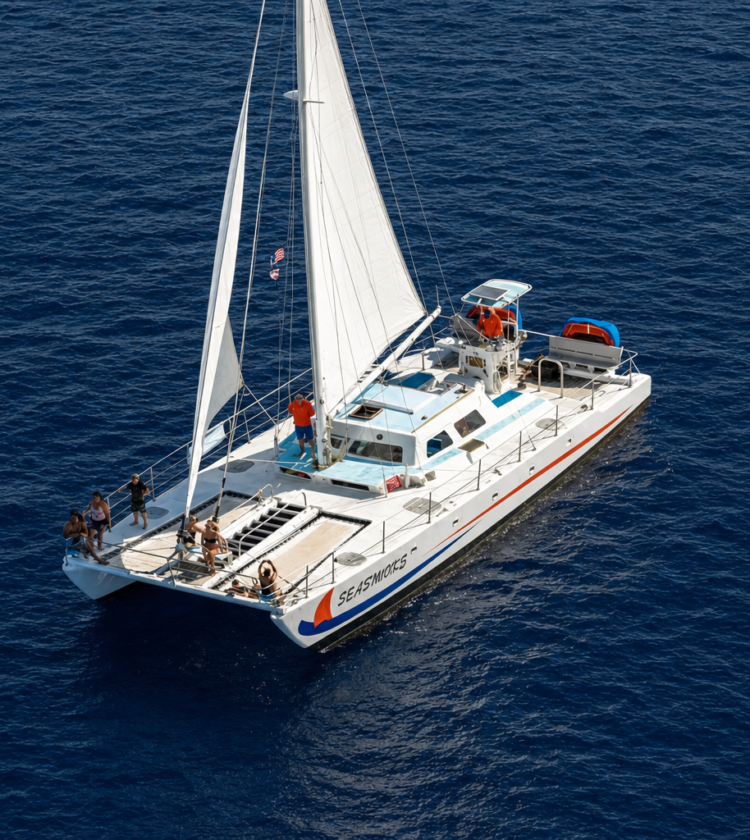 white sailboat named Seasworks with passengers sailing on dark blue ocean