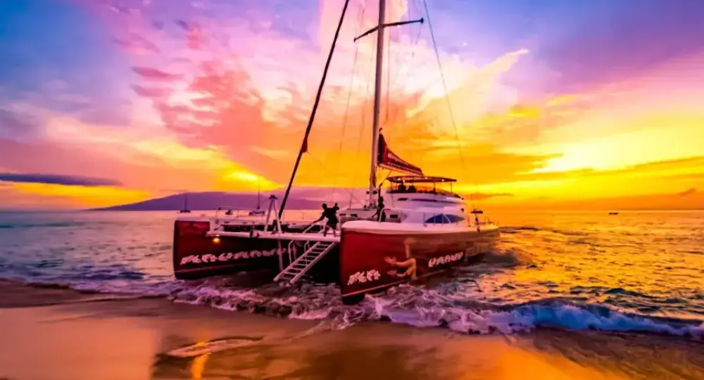 catamaran sailboat on shore during vibrant sunset over ocean