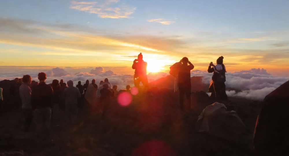 Crowd watching a scenic sunset over clouds