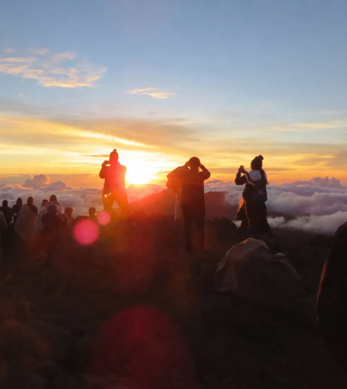 Crowd watching a scenic sunset over clouds