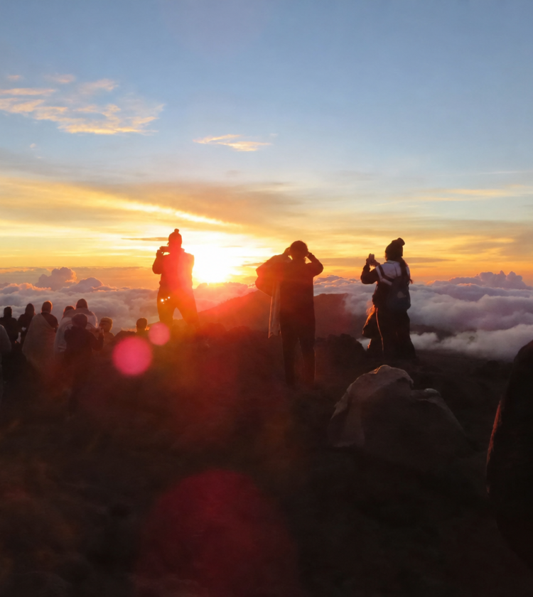 Crowd watching a scenic sunset over clouds
